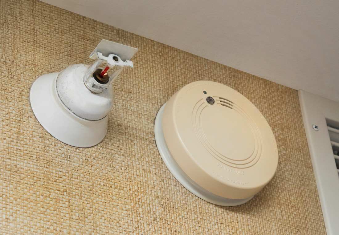 fire sprinkler and a smoke alarm next to each other